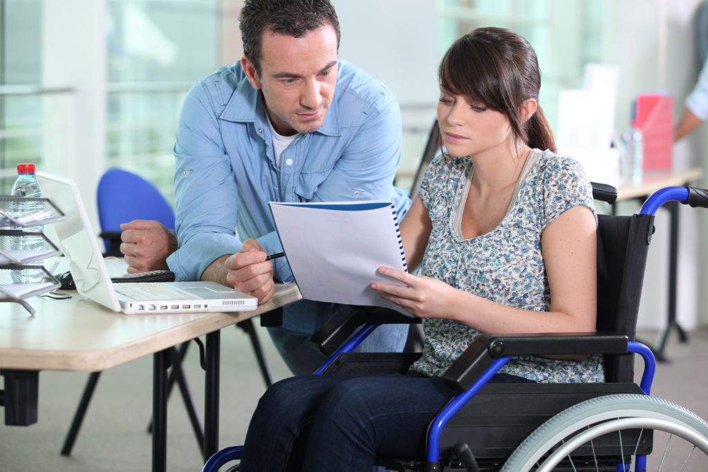 Young woman in wheelchair working with a male colleague Social Security Disability