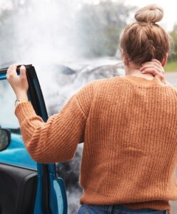 A woman who was in a car accident, holding her neck in discomfort.