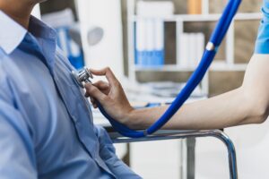 A doctor using a stethoscope while examining a patient.
