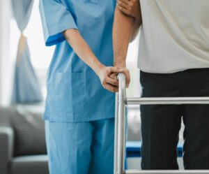 A medical professional helping a patient learn to walk again after a terrible accident.